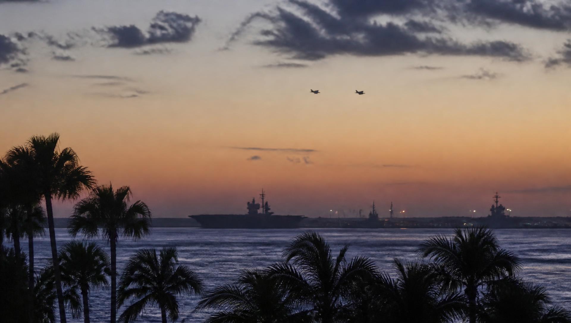 San Diego bay at dusk with naval silhouettes on the horizon